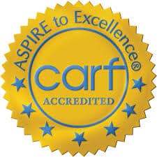 A gold seal with blue text reads ASPIRE to Excellence CARF ACCREDITED and features a circle of blue stars around the border.